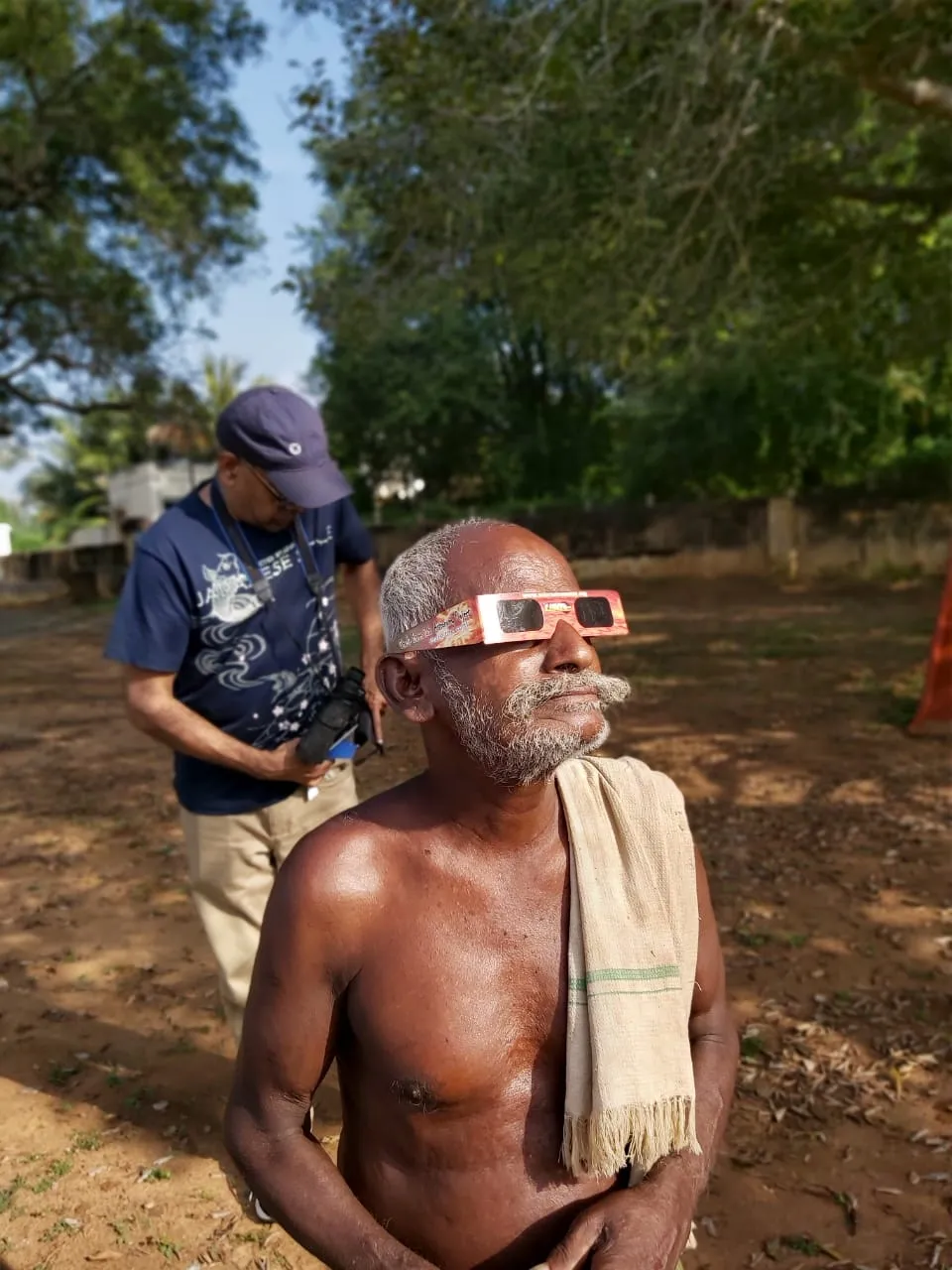 Community member viewing a solar eclipse through safety glasses at an outreach event